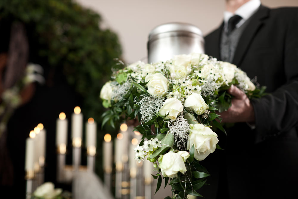 En vit begravningsbukett med rosor