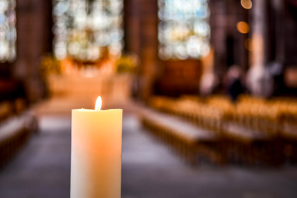 Ett tänt blockljus i en kyrka